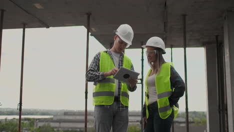 Construction-site-Team-or-architect-and-builder-or-worker-with-helmets-discuss-on-a-scaffold-construction-plan-or-blueprint-or-checklist